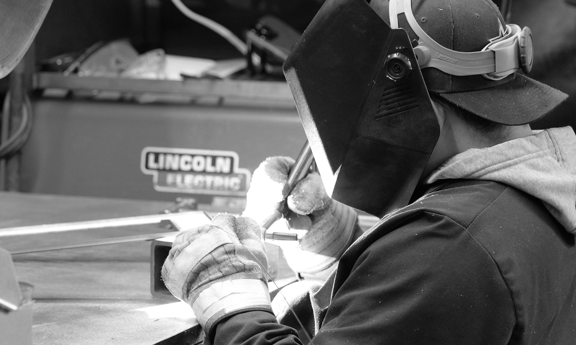 man welder working in black and white