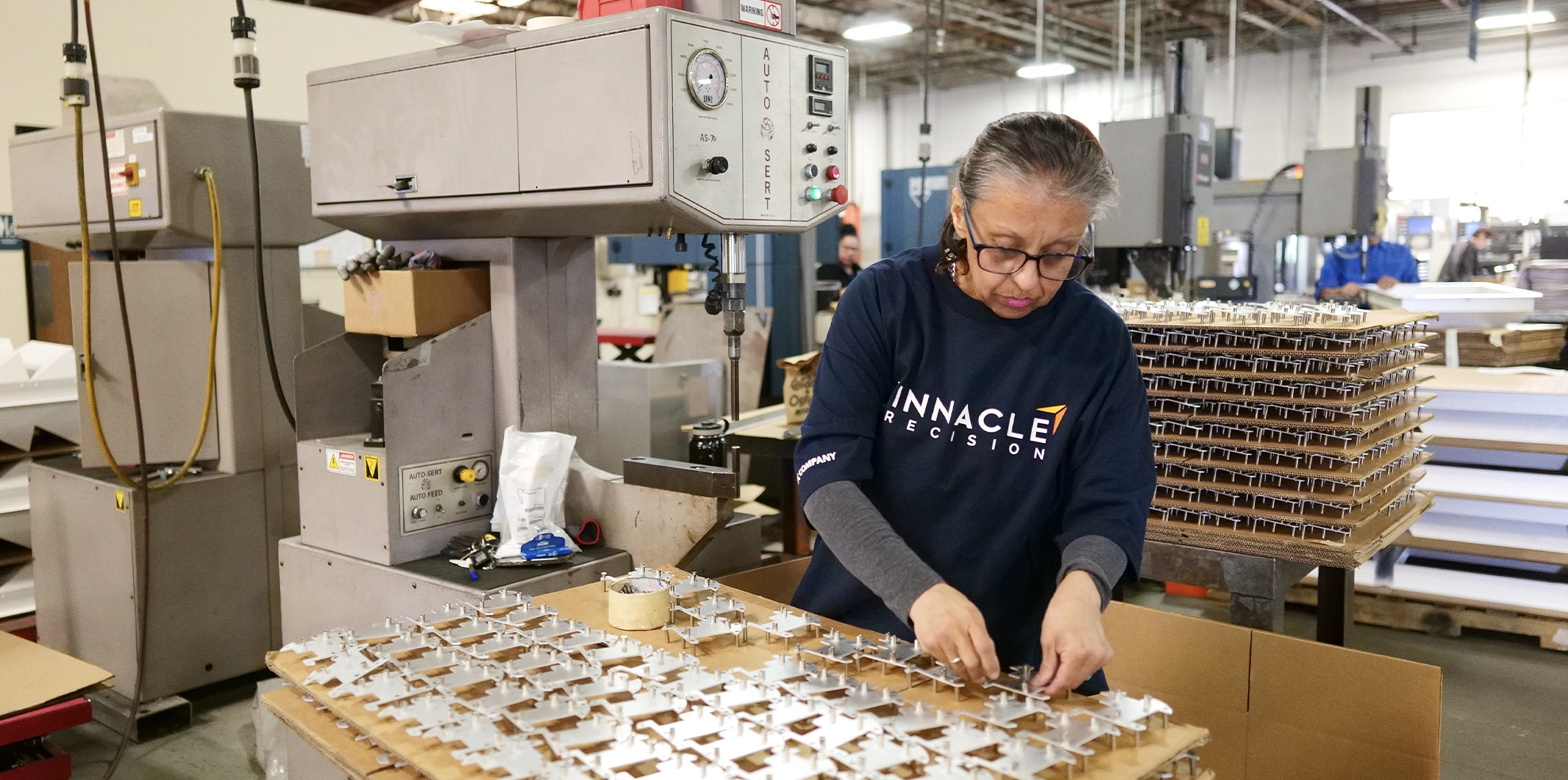 Woman working on precision metal fabrication project