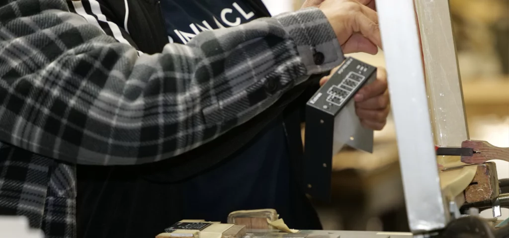 Finisher using silk screening techniques on a metal part in the final stages of the part production